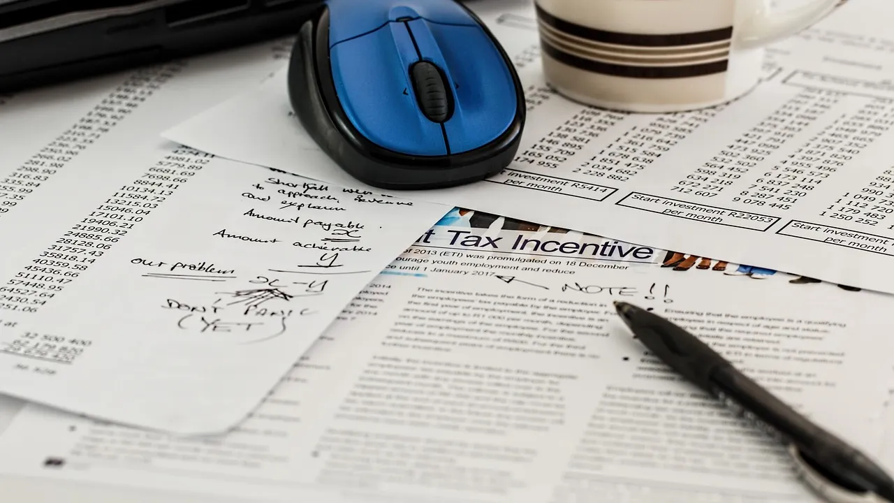 Tax forms and a pen on a desk
