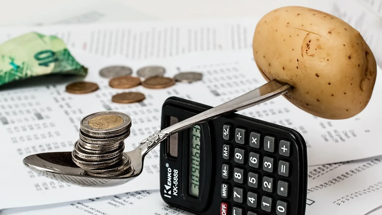 Coins stacked near a glass savings jar